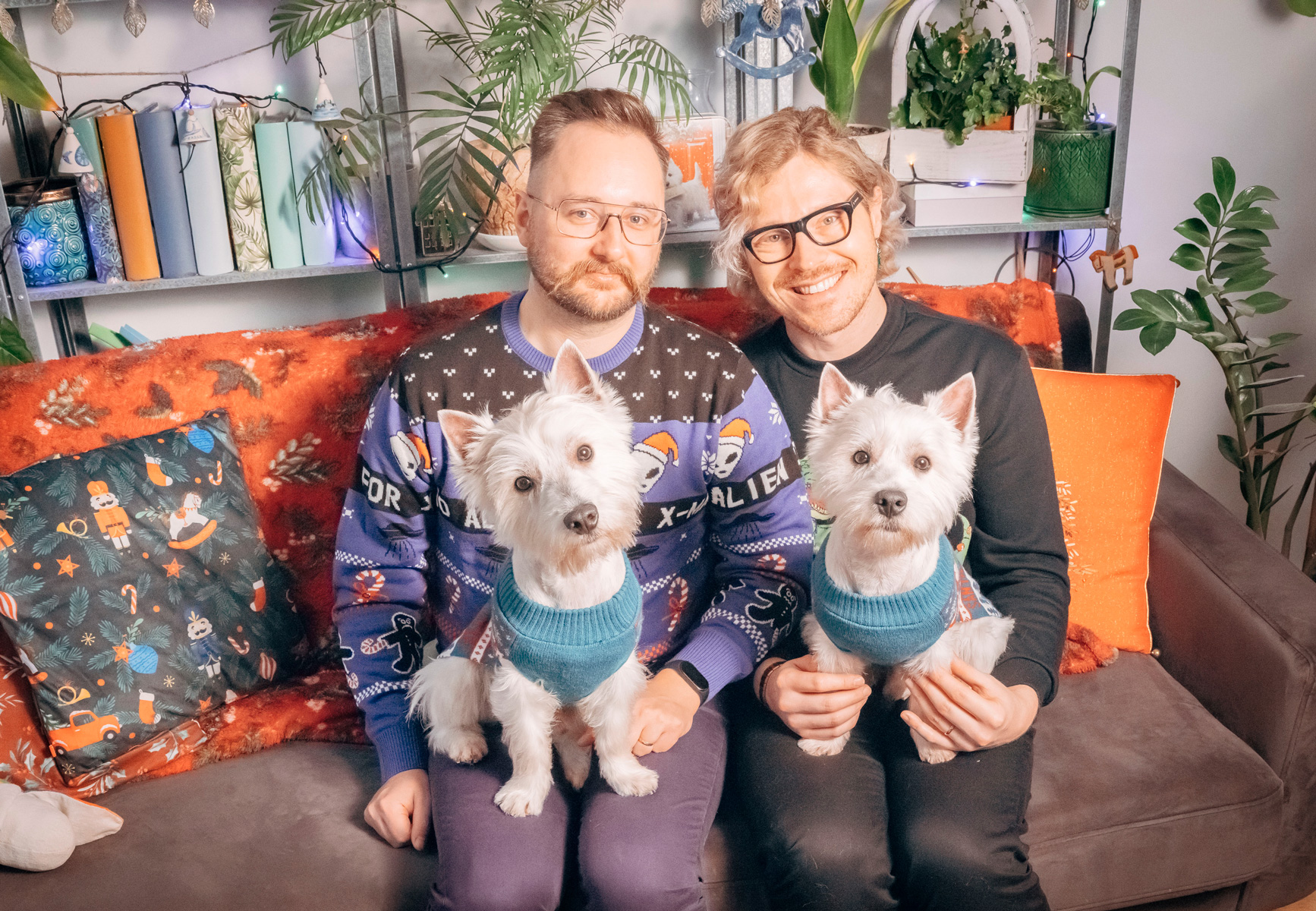 two men sitting on a couch with two dogs on their laps - conversation graphic