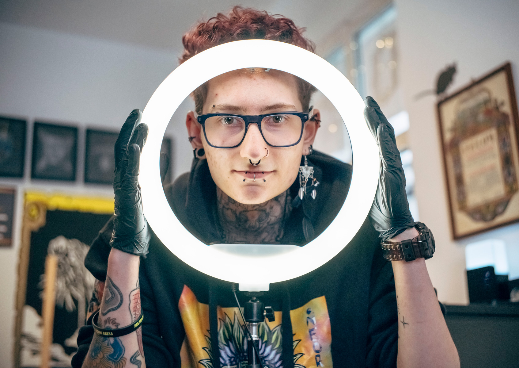 young man wearing glasses holding a circular lamp - conversation graphic