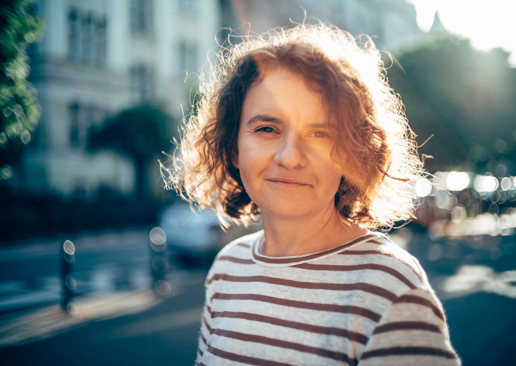 woman with curly hair smiling - conversation graphic
