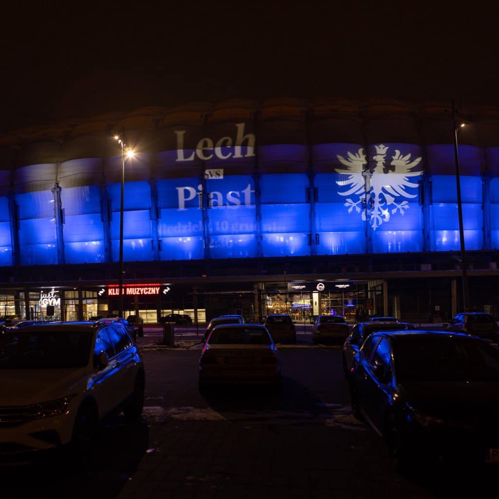 Specjalnie podświetlony stadion przy ul. Bułgarskiej na niebiesko z napisem Lech - Piast - grafika rozmowy