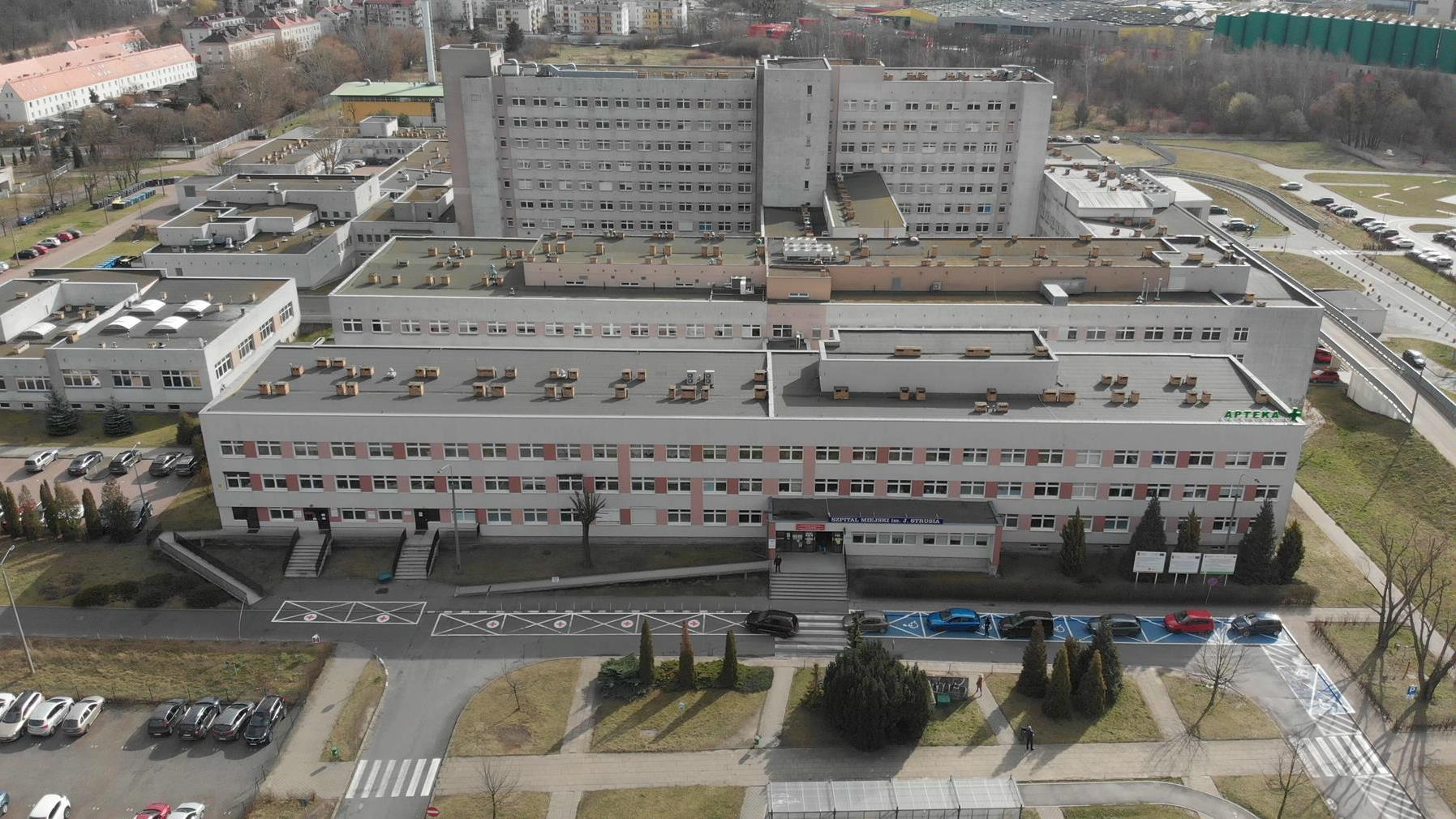 Zdjęcie szpitala im. J. Strusia z lotu ptaka, na pierwszym planie parking, za nim budynki lecznicy - grafika rozmowy