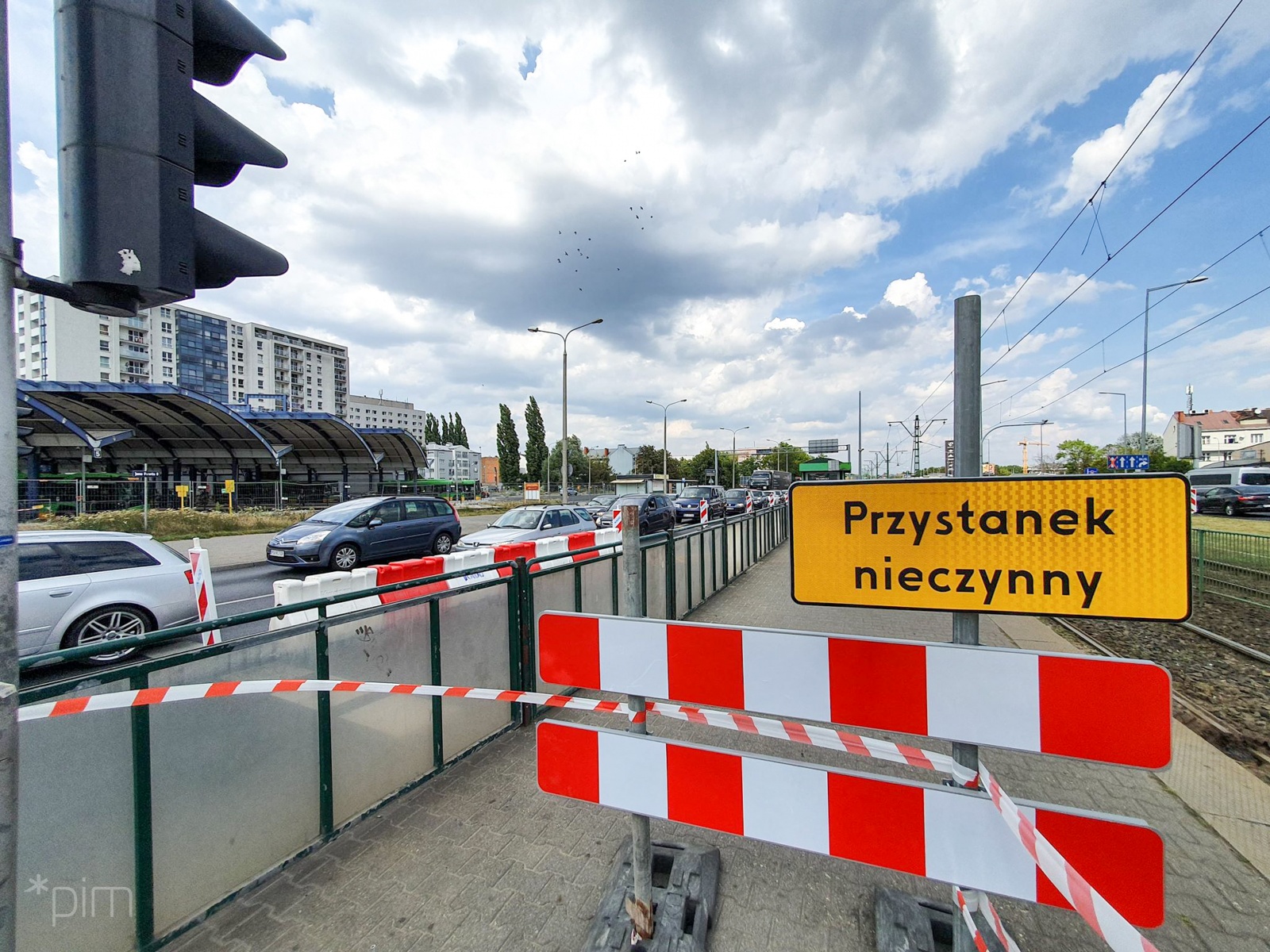Na zdjęciu znajduje się jezdnia, po której jadą samochody oraz nieczynny przystanek - grafika rozmowy