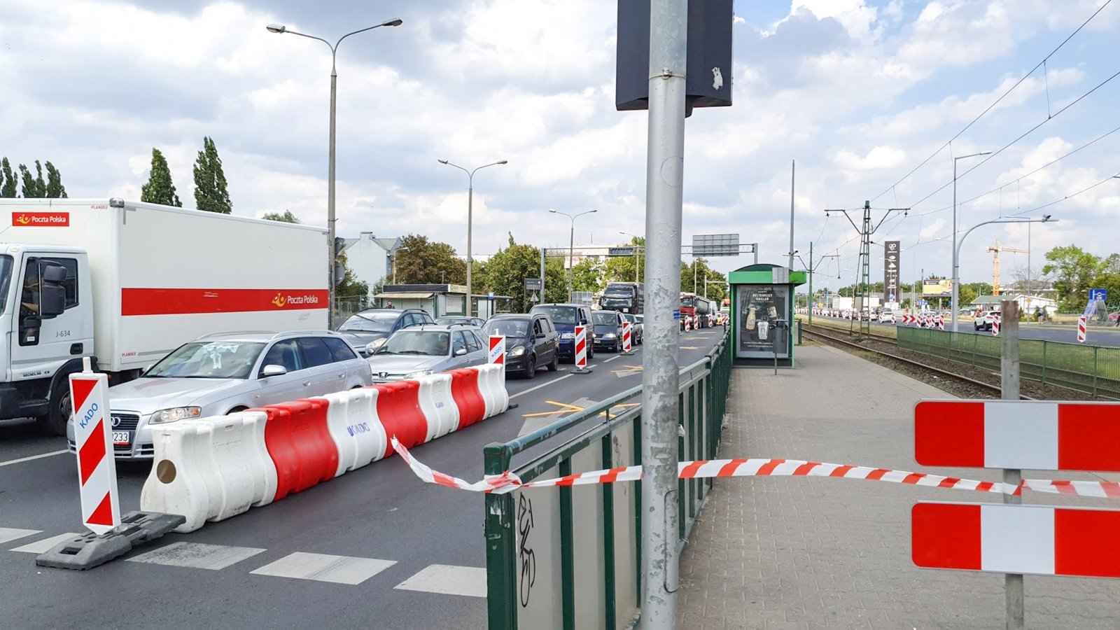 Na zdjęciu znajduje się jezdnia, po której jadą samochody oraz nieczynny przystanek