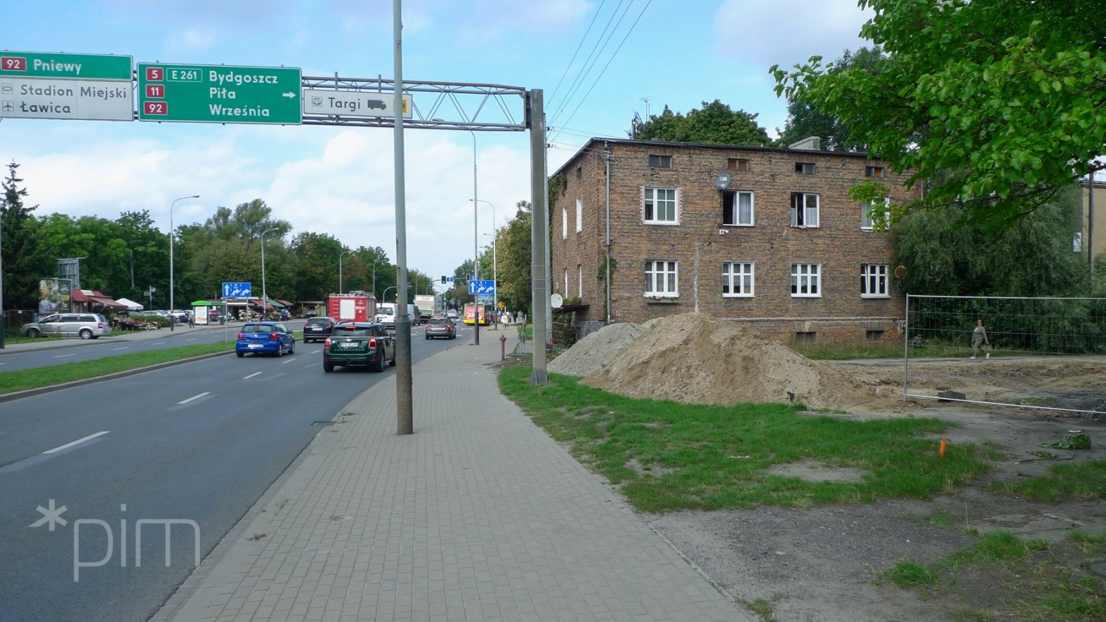 Ulica Ściegiennego. Widać kratownicę z drogowskazami dróg krajowych. Na wprost dom. Po prawej wykopy