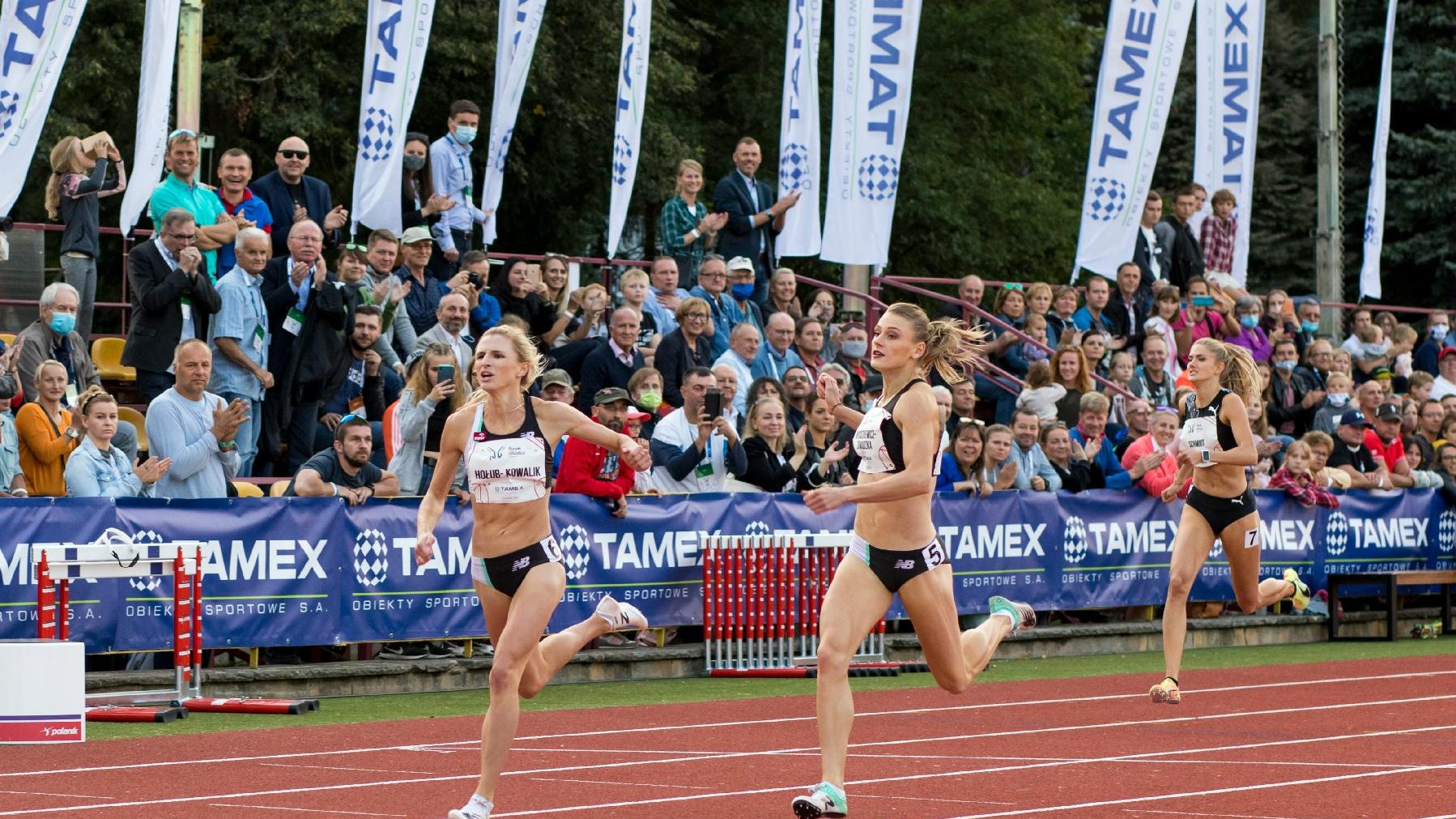 Zawodniczki w biegu na 400 metrów wbiegają na metę. W tle trybuny stadionu na Golęcinie