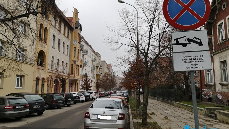 Dużo zaparkowanych samochodów po obu stronach ulicy