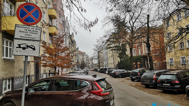 Dużo zaparkowanych samochodów po obu stronach ulicy