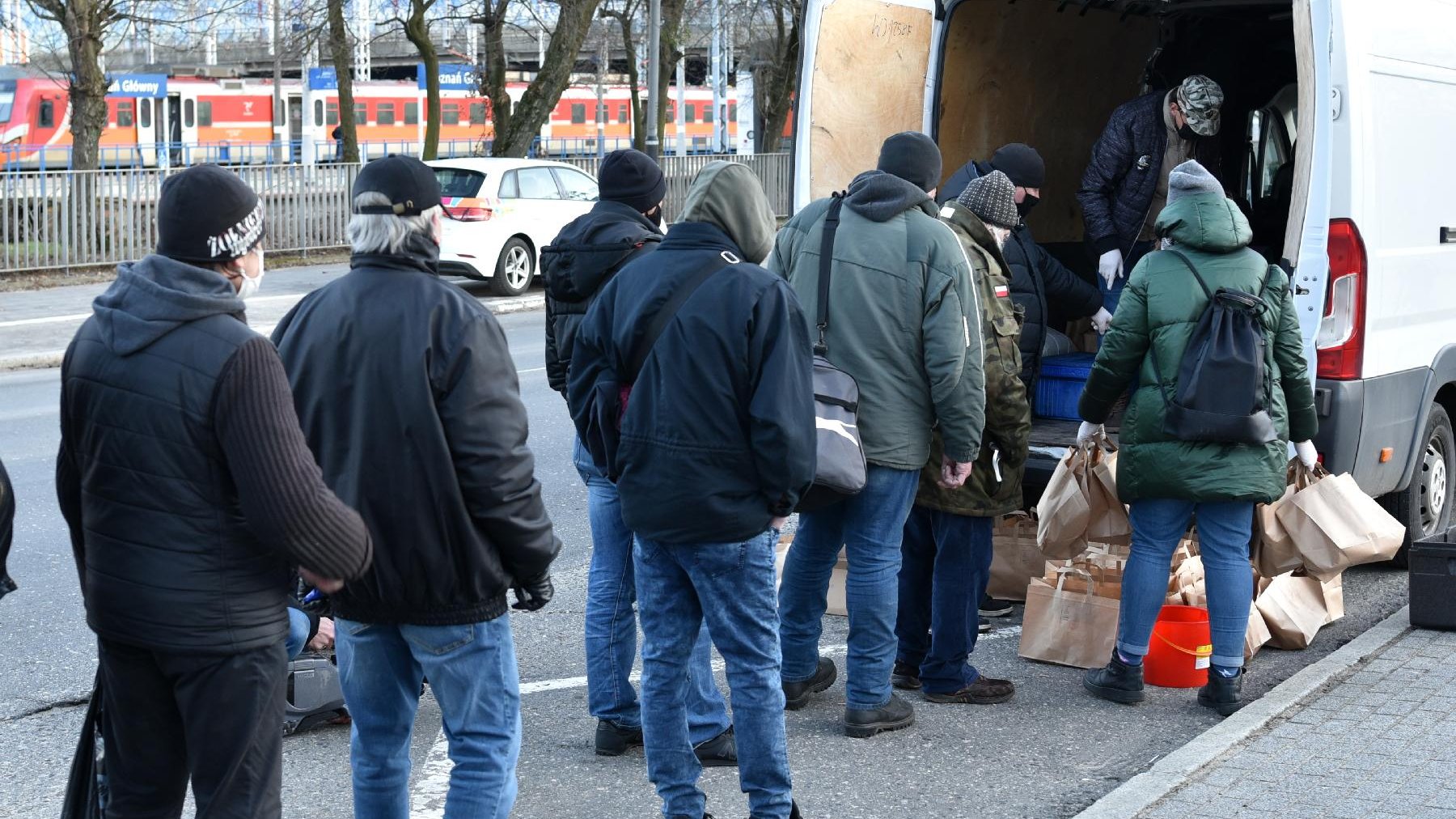 Galeria zdjęć przedstawia wydawanie posiłków potrzebującym.