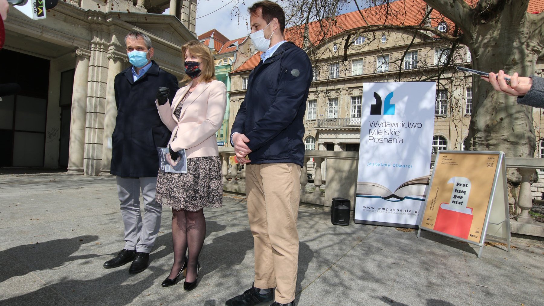 Zdjęcie przedstawia wiceprezydenta Jędrzeja Solarskiego, dyrektorkę Wydawnictwa Miejskiego Posnania - Katarzynę Kamińską oraz radnego miejskiego Grzegorza Jurę, stojących na placu przed Arkadią.