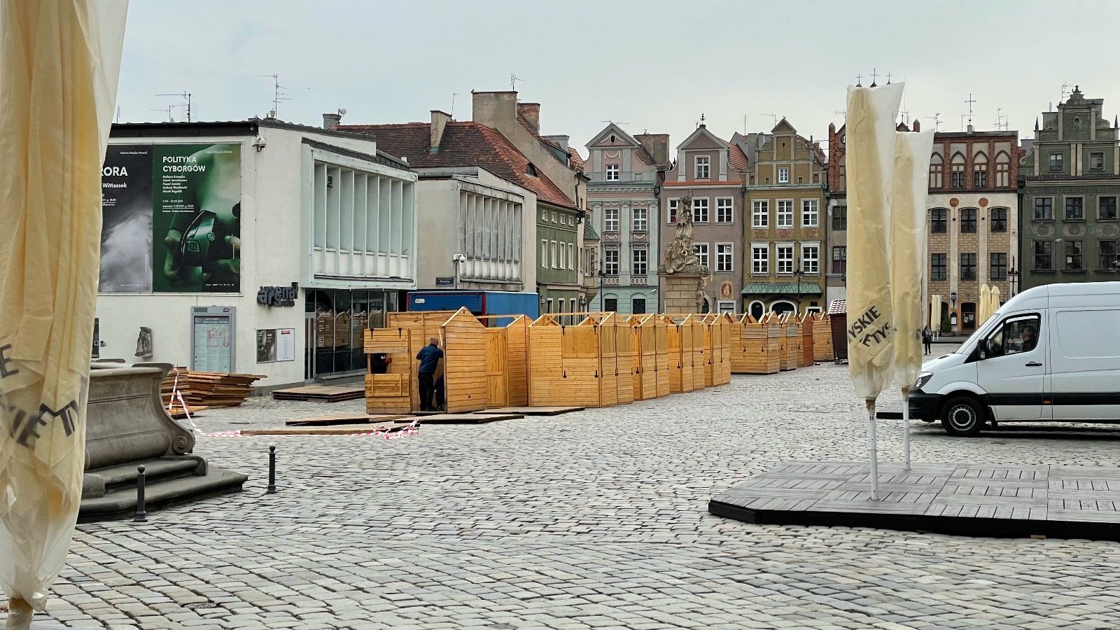 Galeria zdjęć przedstawia montaż drewnianych domków handlowych na Starym Rynku.