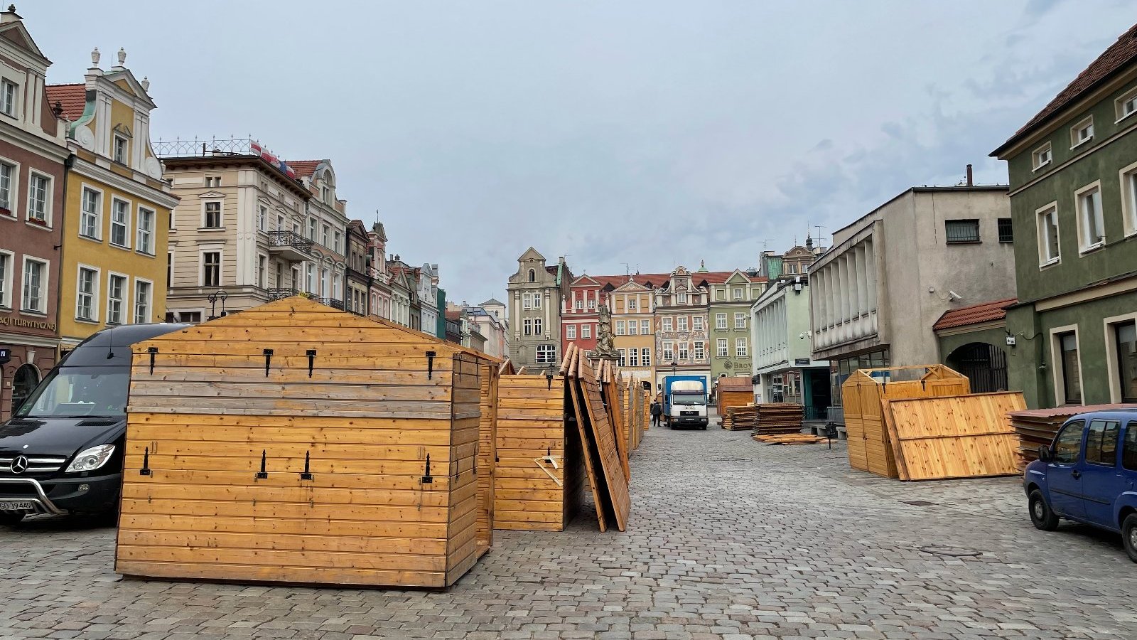 Galeria zdjęć przedstawia montaż drewnianych domków handlowych na Starym Rynku.