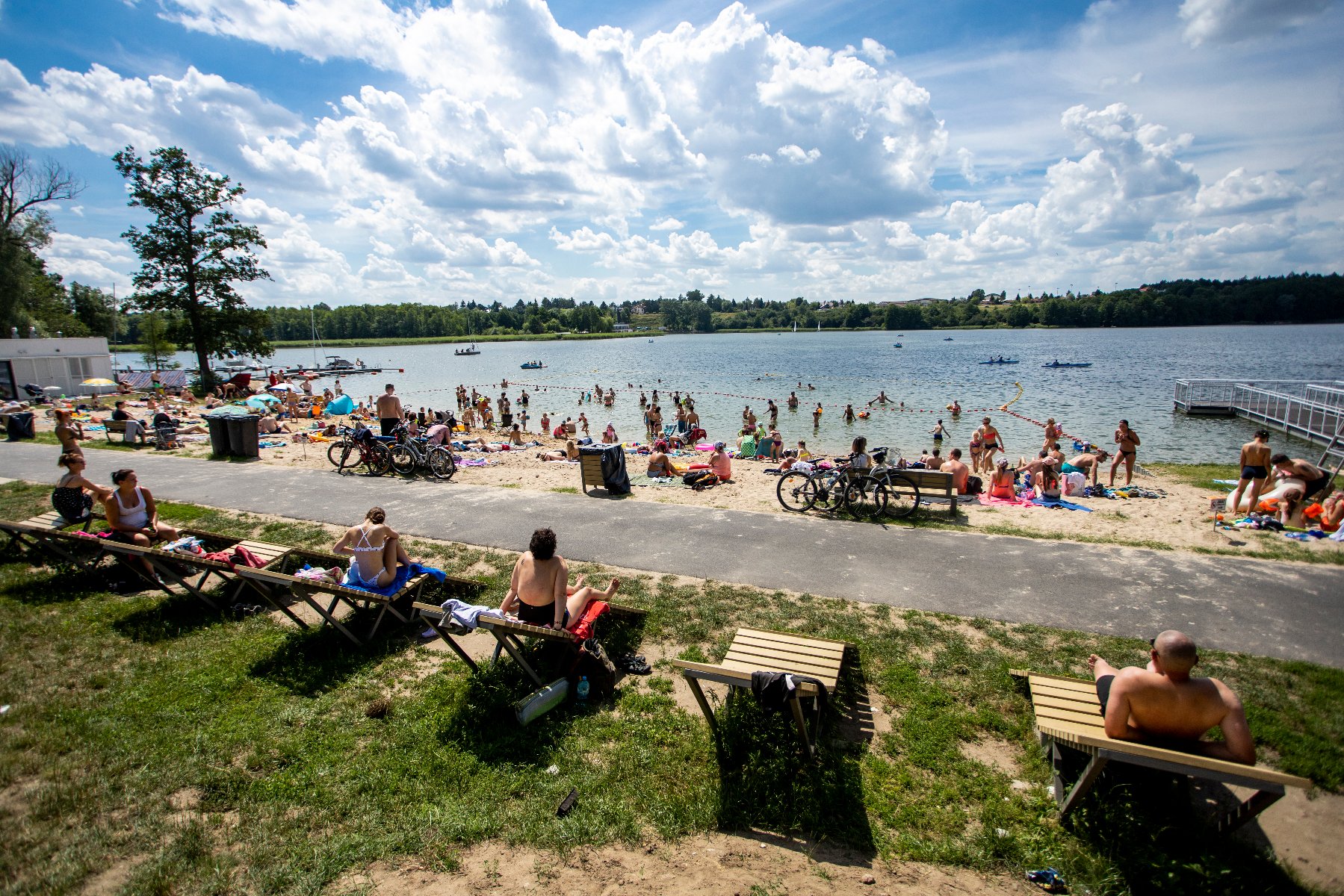 Zdjęcie przedstawia ludzi siedzących na plaży. - grafika rozmowy