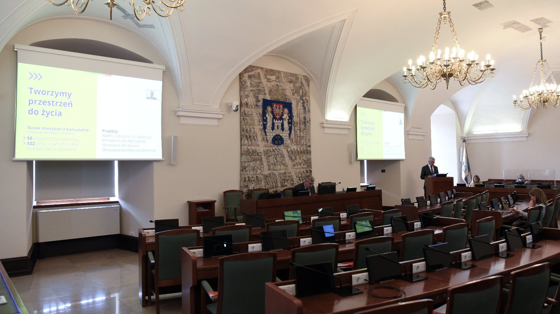 Na zdjęciu Jacek Jaśkowiak, prezydent Poznania, w niemal pustej sali sesyjnej urzędu miasta, obok Grzegorz Ganowicz, przewodniczący rady miasta