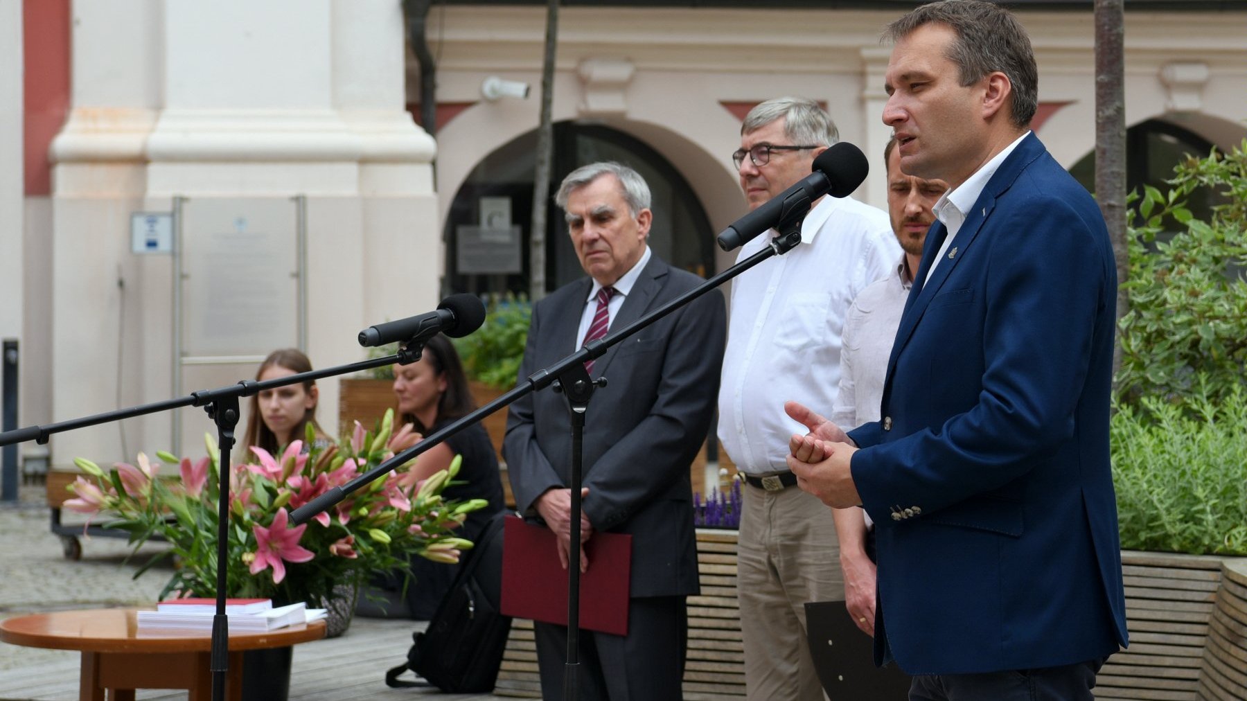 Dziedziniec Urzędu Miasta Poznania. Na pierwszym planie przy mikrofonie Mariusz Wiśniewski, zastępca prezydenta miasta