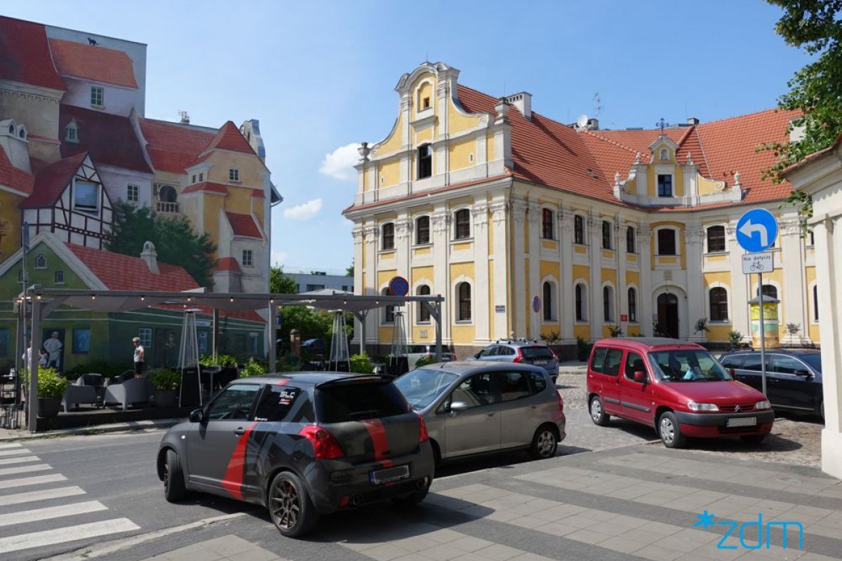 Zdjęcie pokazuje cześć Śródki z muralem (po lewej stronie) - grafika rozmowy