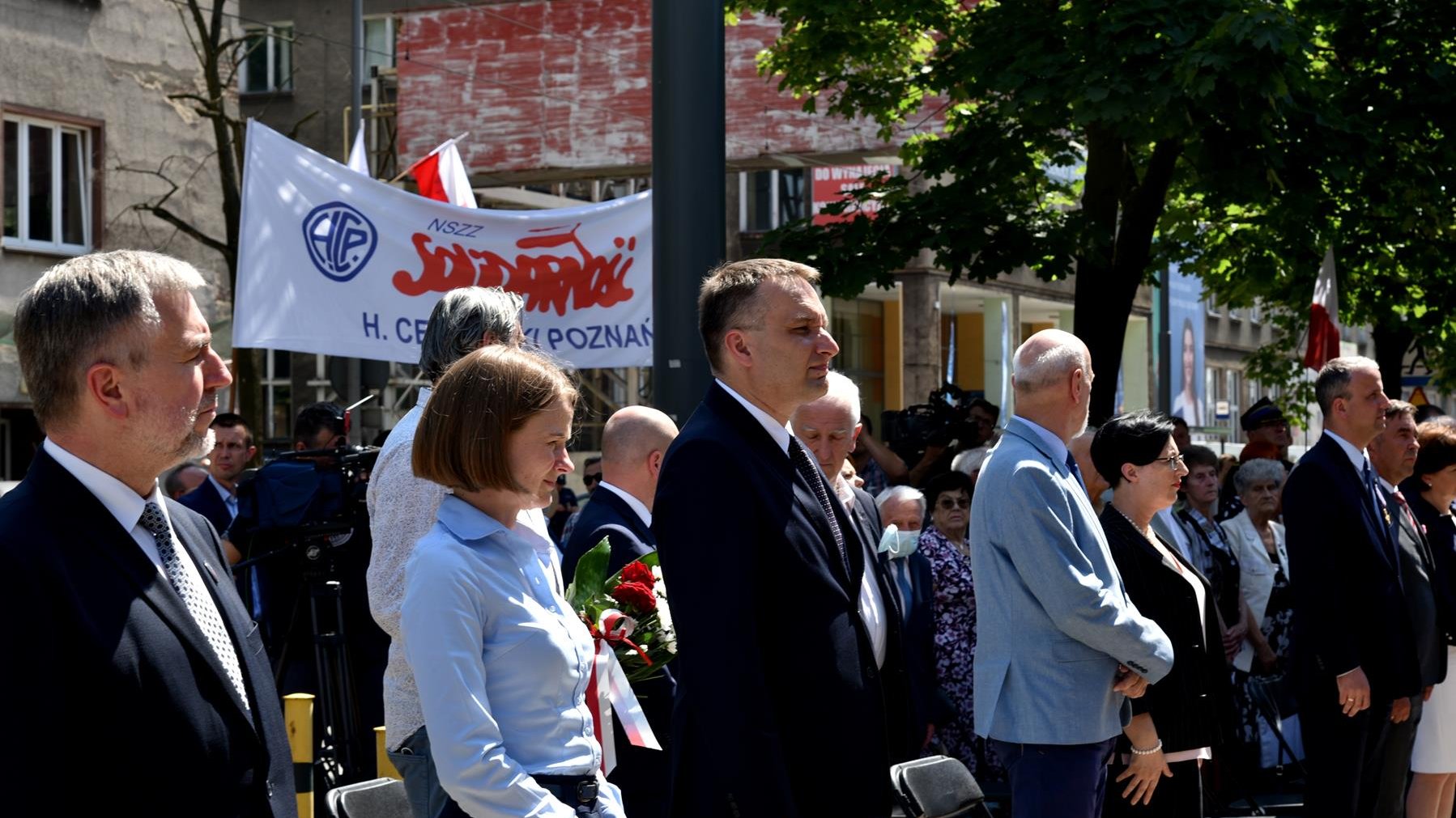 Grupa ludzi, na pierwszym planie marszałek województwa i zastępca prezydenta Poznania, w tle baner z napisem"Solidarność"