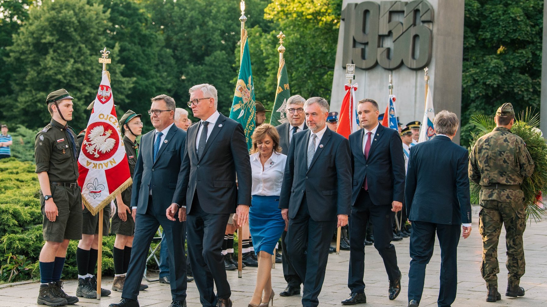 Grupa osób po złożeniu wieńca, przedstawiciele samorządu miasta i regionu, w tle Pomnik Poznańskiego Czerwca