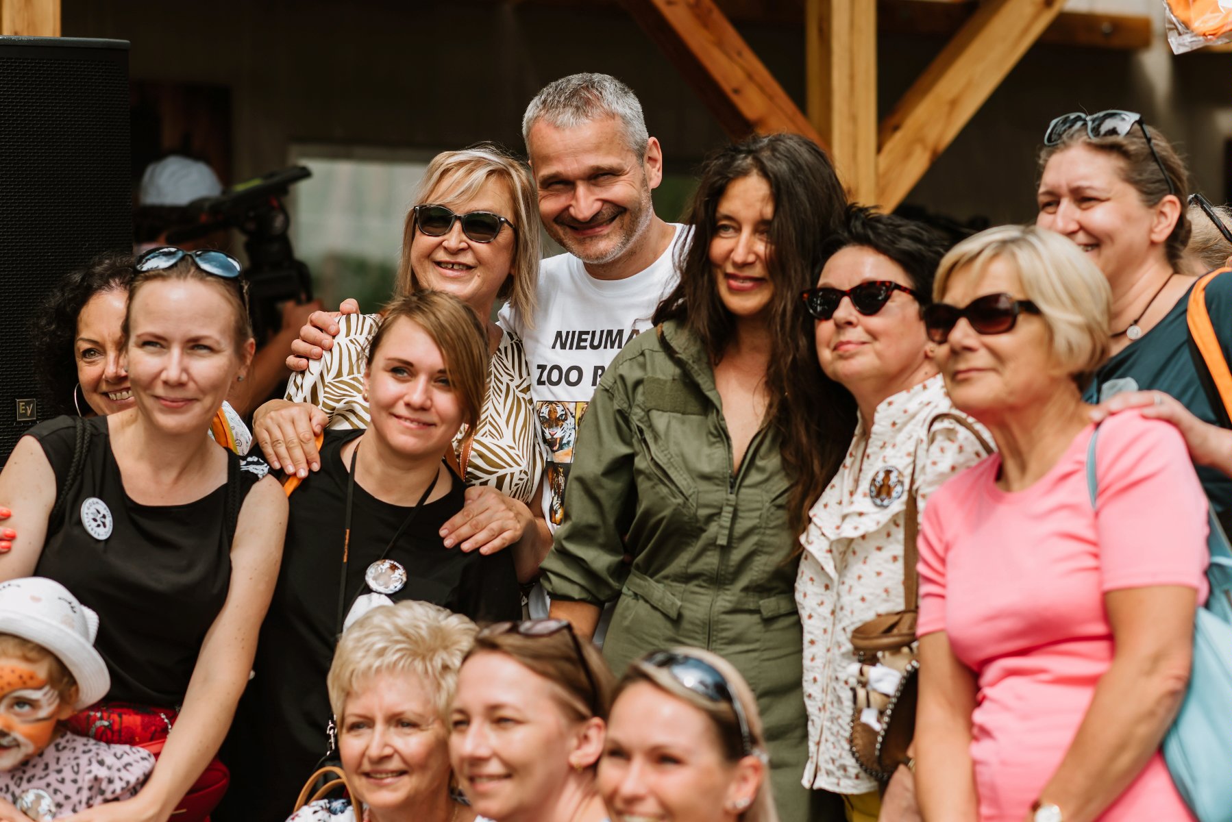 Na zdjęciu pracownicy zoo i goście pozują do zdjęcia, w środku Jędrzej Solarski, zastępca prezydenta Poznania i Ewa Zgrabczyńska, dyrektor zoo - grafika rozmowy