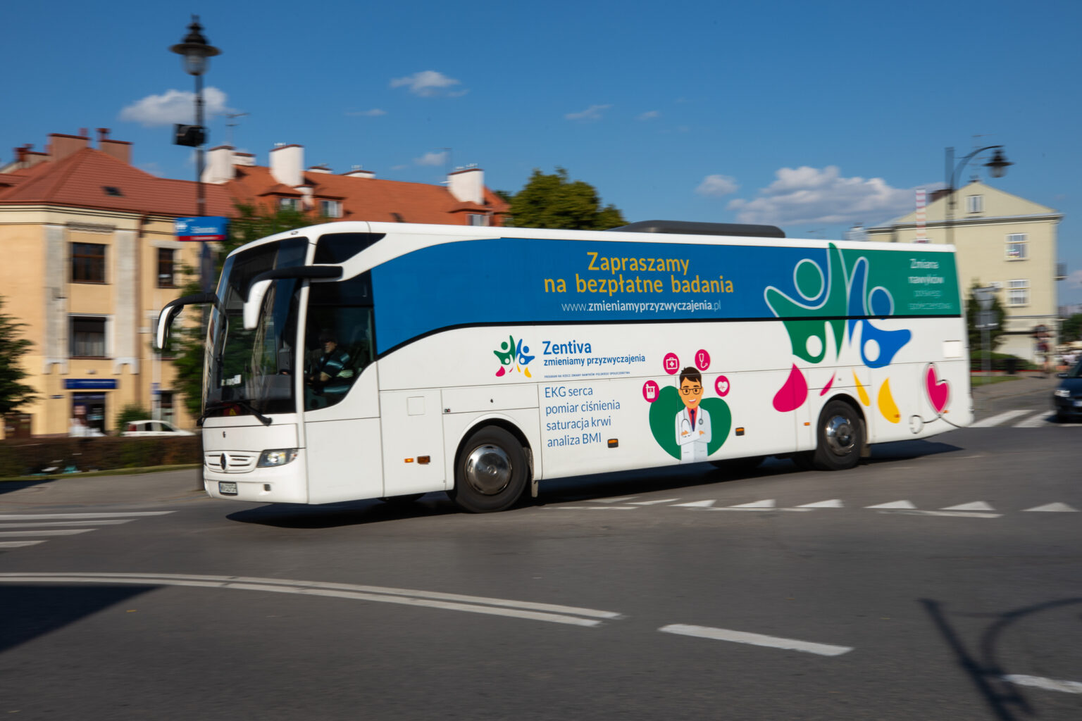 Na zdjęciu duży autobus z napisem: zapraszamy na bezpłatne badania - grafika rozmowy