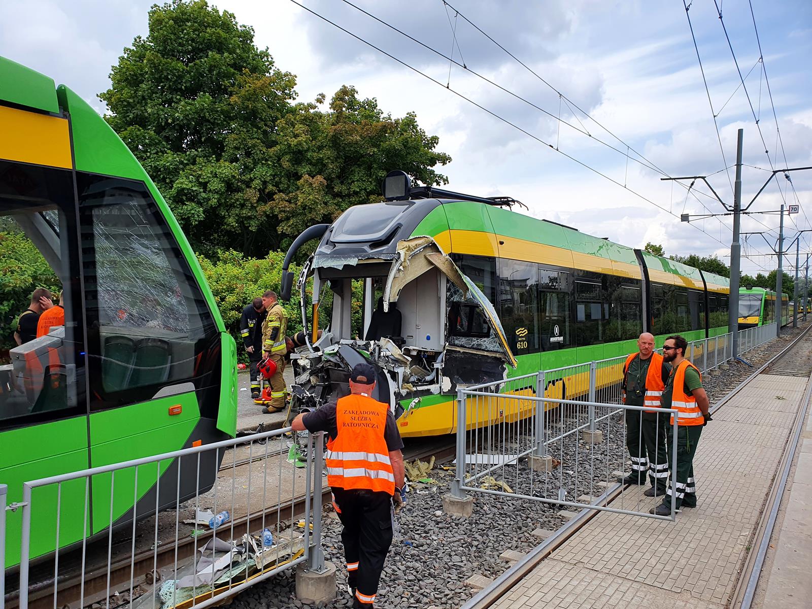 Na zdjęciu dwa tramwaje, jeden z nich ma całkowicie zniszczoną kabinę motorniczego - grafika rozmowy