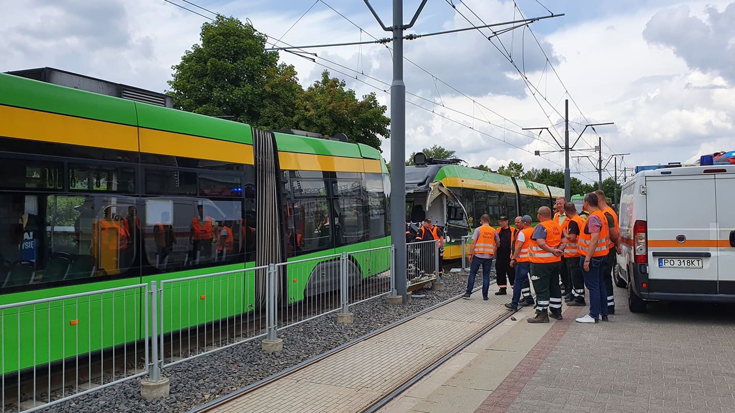 Na zdjęciu dwa tramwaje, jeden z nich ma całkowicie zniszczoną kabinę motorniczego, obok stoją pracownicy MPK