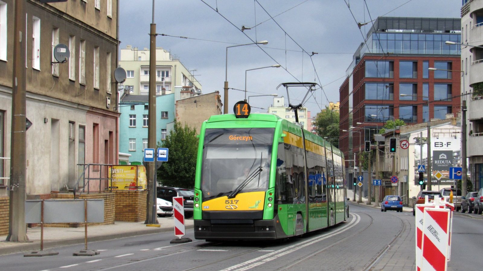 Tramwaj zbliżający się do przystanku, po prawej stronie widać przebudowywaną platformę