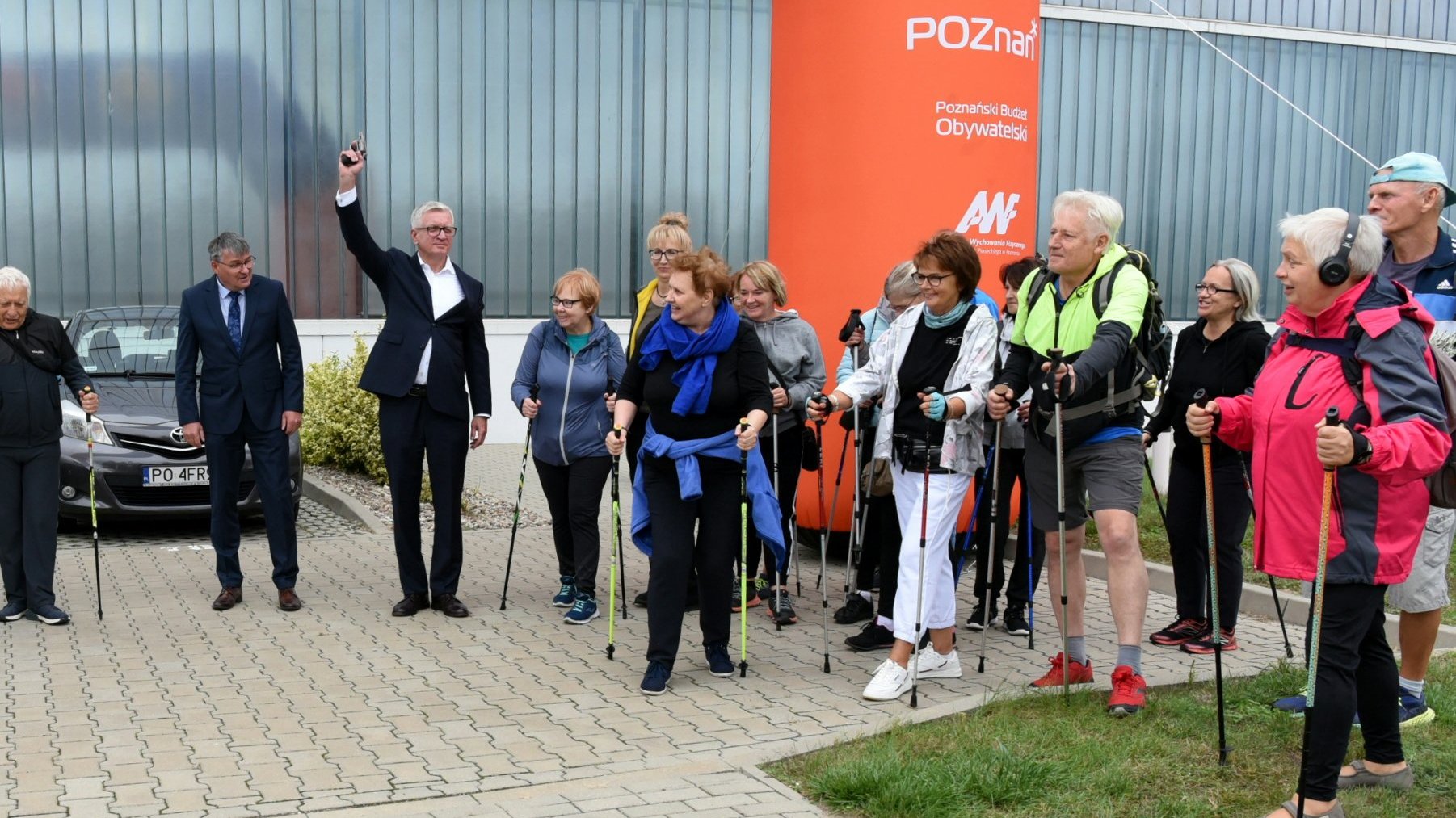 Jacek Jaśkowiak, prezydent Poznania, rozpoczyna marsz nordic walking, strzelając w niebo, obok seniorzy