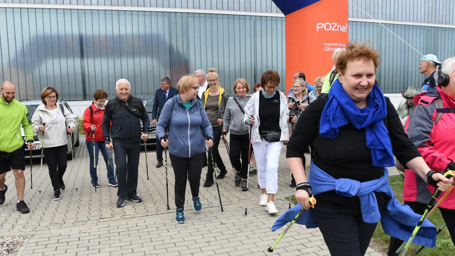 Grupa seniorów maszerująca z kijkami do nordic walking