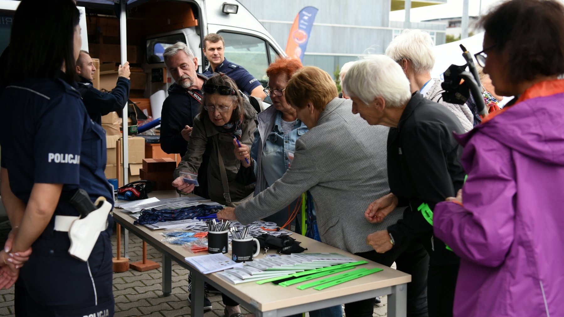 Seniorzy skupieni wokół stoiska policjantów