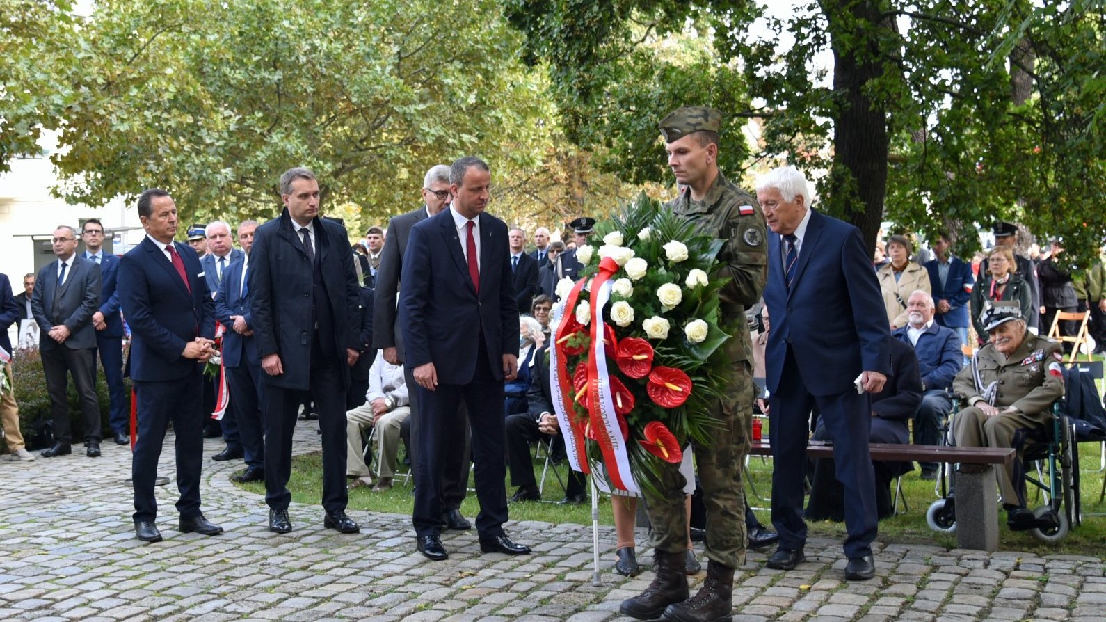 Zdjęcie przedstawia przedstawicieli władz samorządowych i wojewódzkich, składających kwiaty pod pomnikiem.