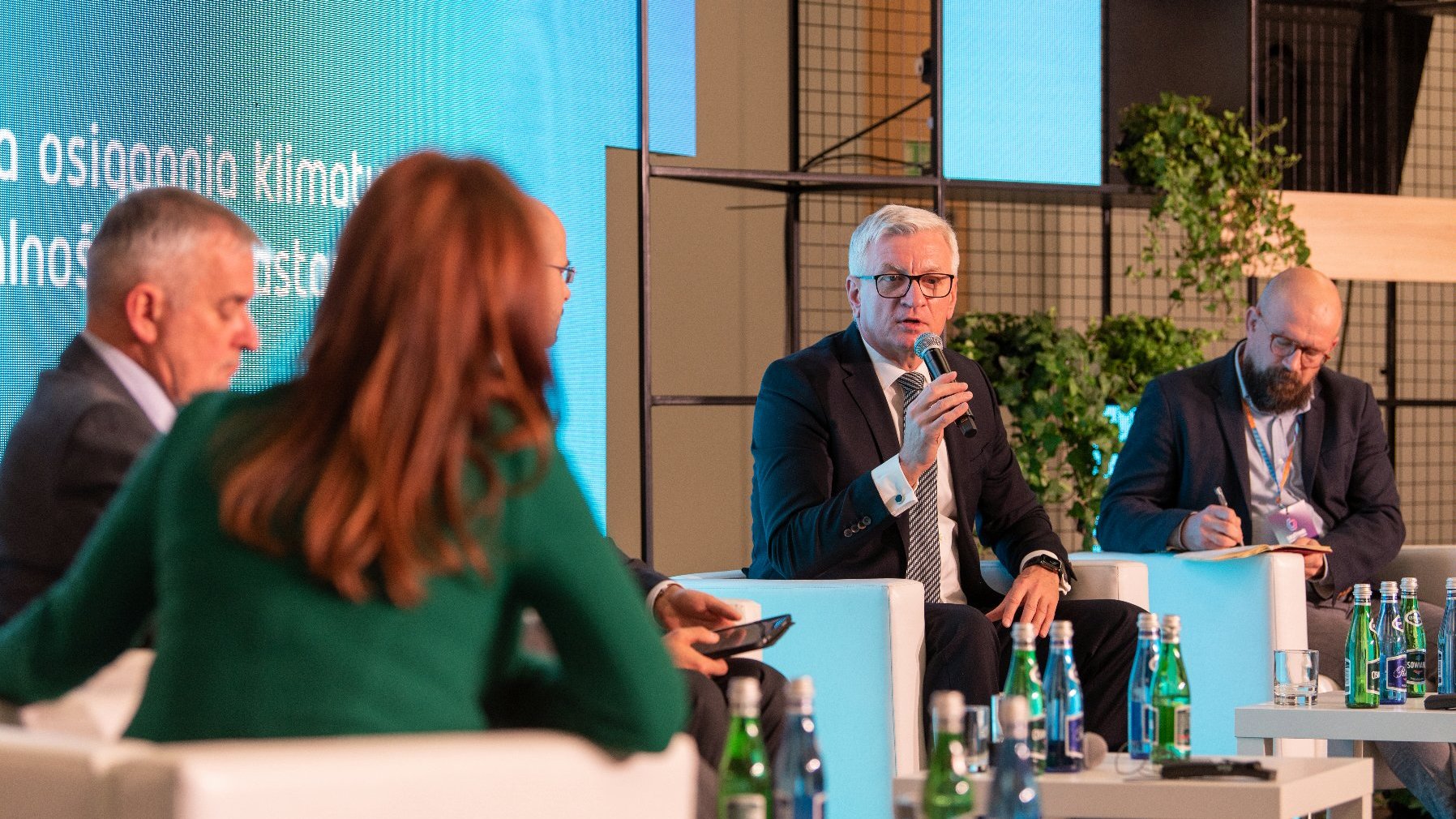 na zdjęciu debata, paneliści siedzą na scenie, Jacek Jaśkowiak z mikrofonem w ręku