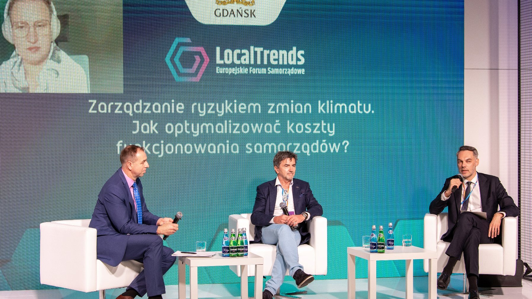 Na zdjęciu trzech panelistów, w tym Piotr Husejko, skarbnik miasta, w tle ekran z tytułem debaty