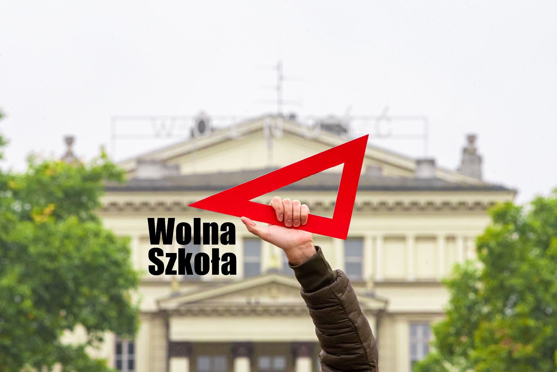 Zdjęcie przedstawia rękę trzymającą czerwoną ekierkę. - grafika rozmowy