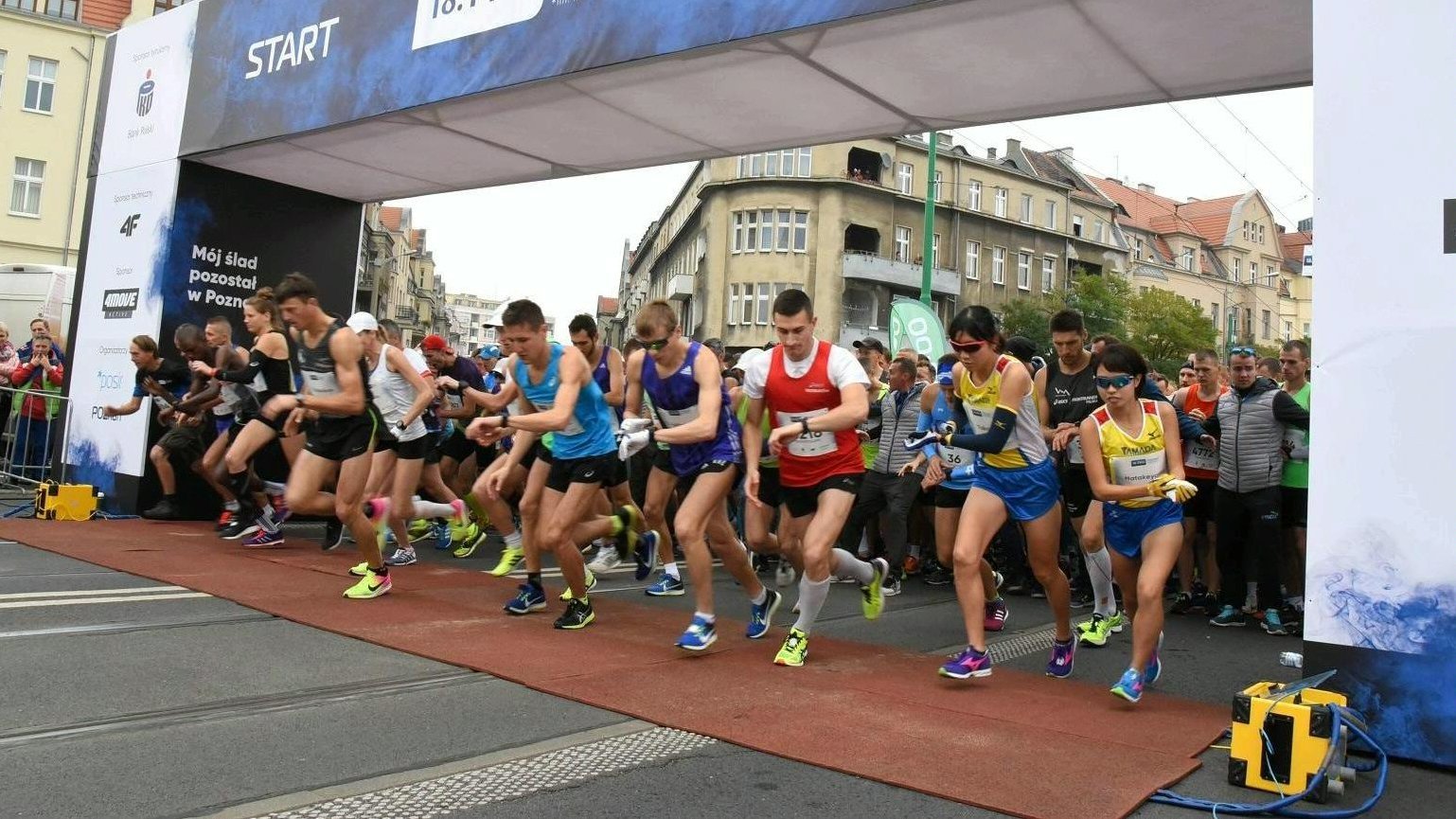 Na zdjęciu start poznańskiego biegu, na starcie dziesiątki biegaczy, którzy właśnie rozpoczynają bieg