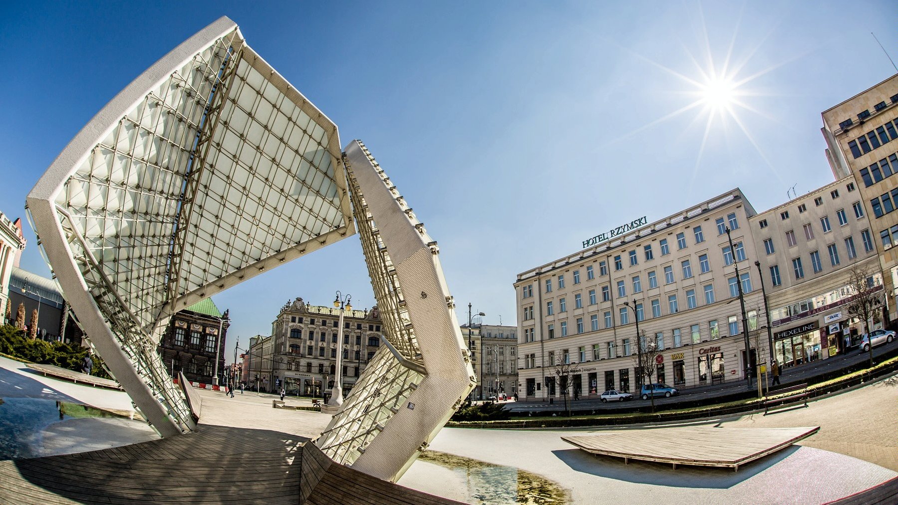 Na zdjęciu plac Wolności, na pierwszym planie fontanna, w tle Hotel Rzymski