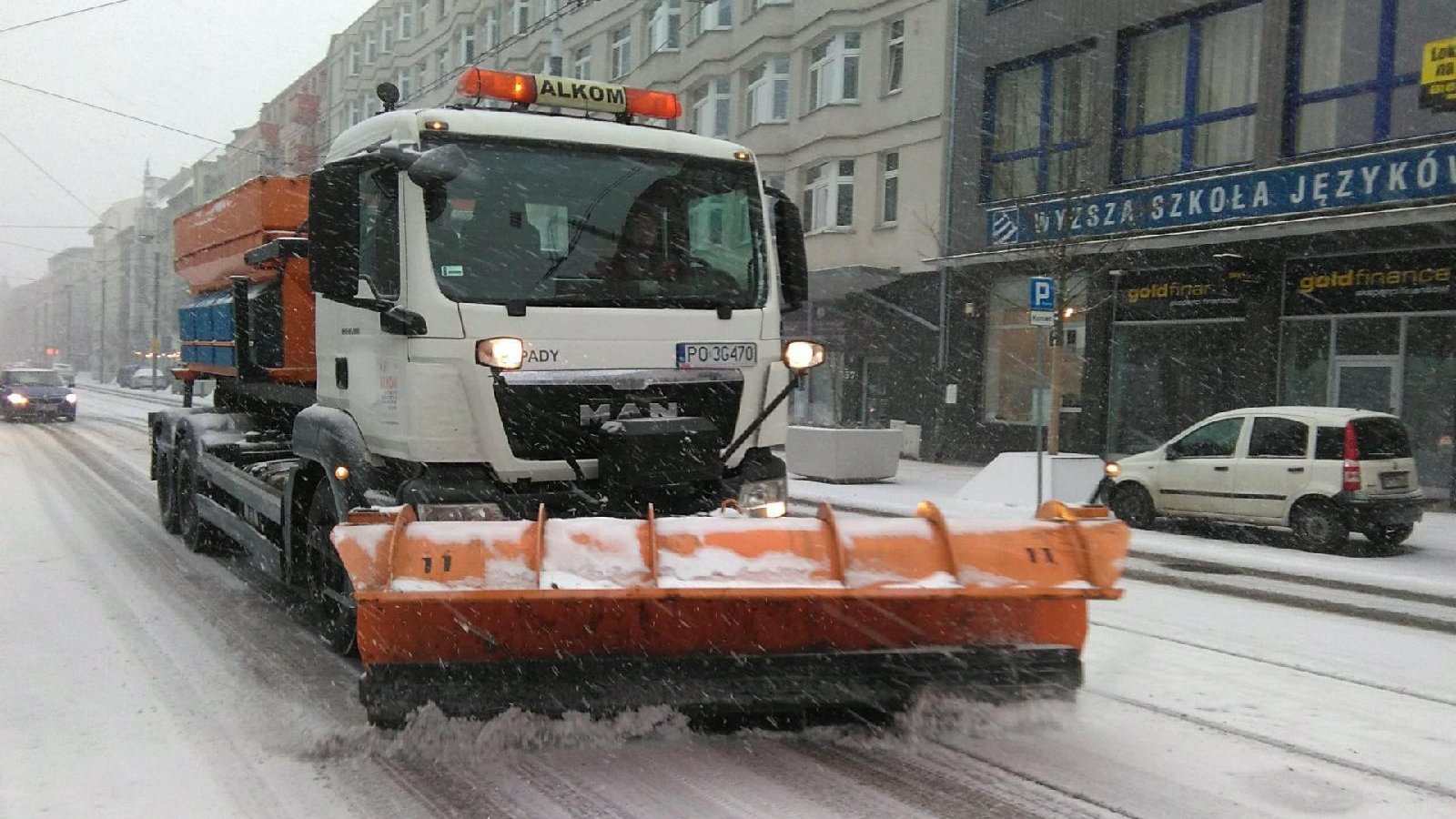 Pługopiaskarka odgarniająca śnieg z ulicy - grafika rozmowy