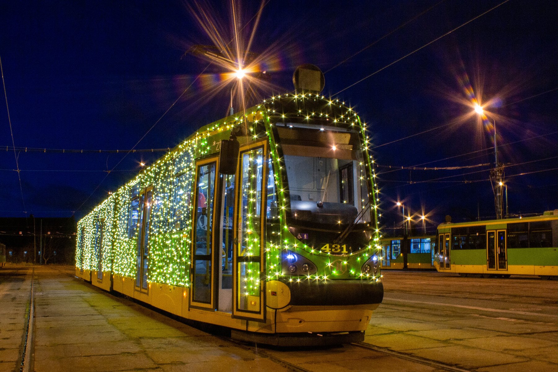 Zdjęcie przedstawia tramwaj ozdobiony świecącymi lampkami. - grafika rozmowy