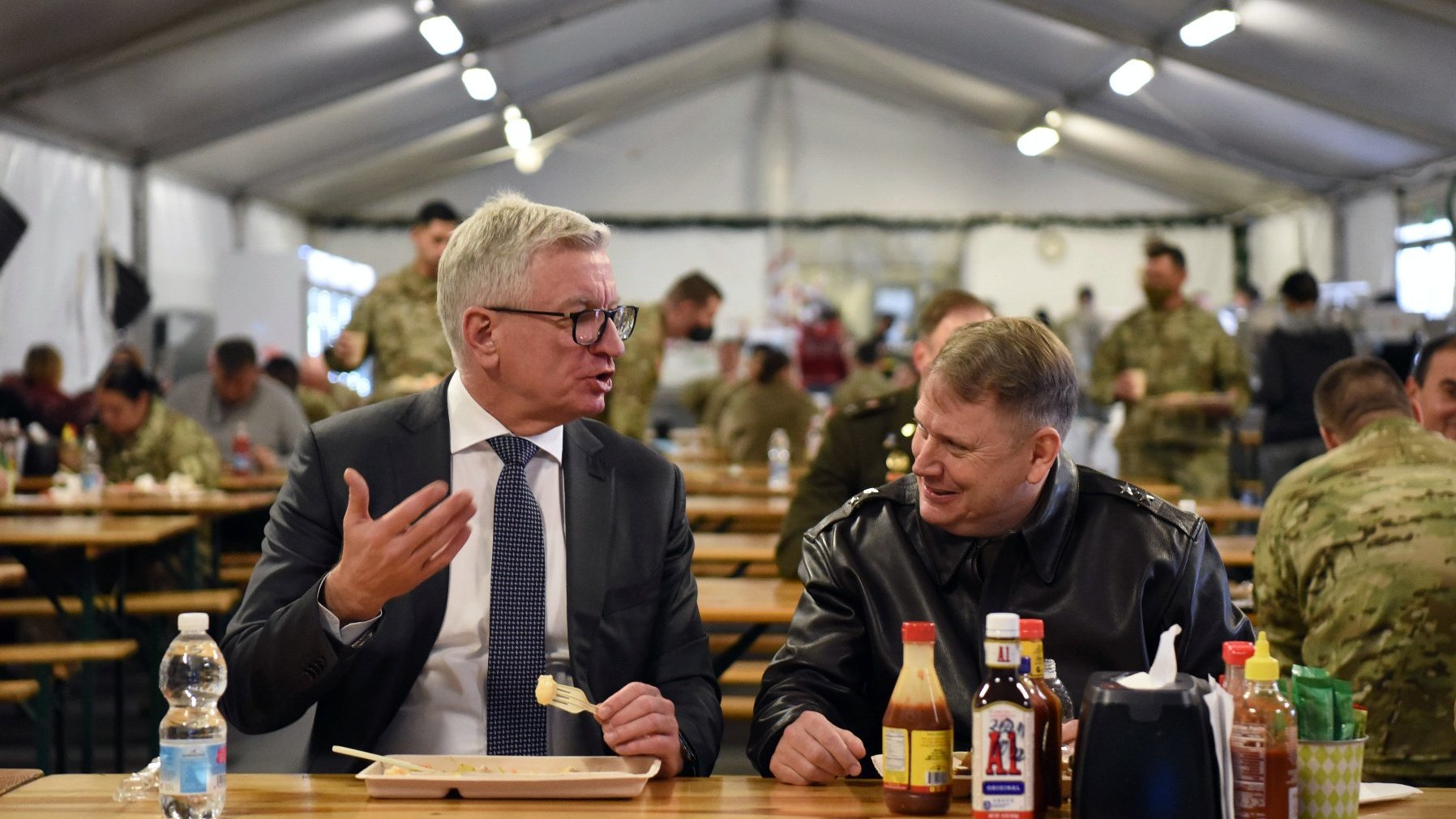 Na zdjęciu Jacek Jaśkowiak i gen Matthew Van Wagenen siedzą w żołnierskiej stołówce, rozmawiając