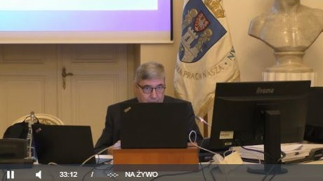 Na zdjęciu Grzegorz Ganowicz, przewodniczący rady miasta, przed monitorem. Screen z posiedzenia rady