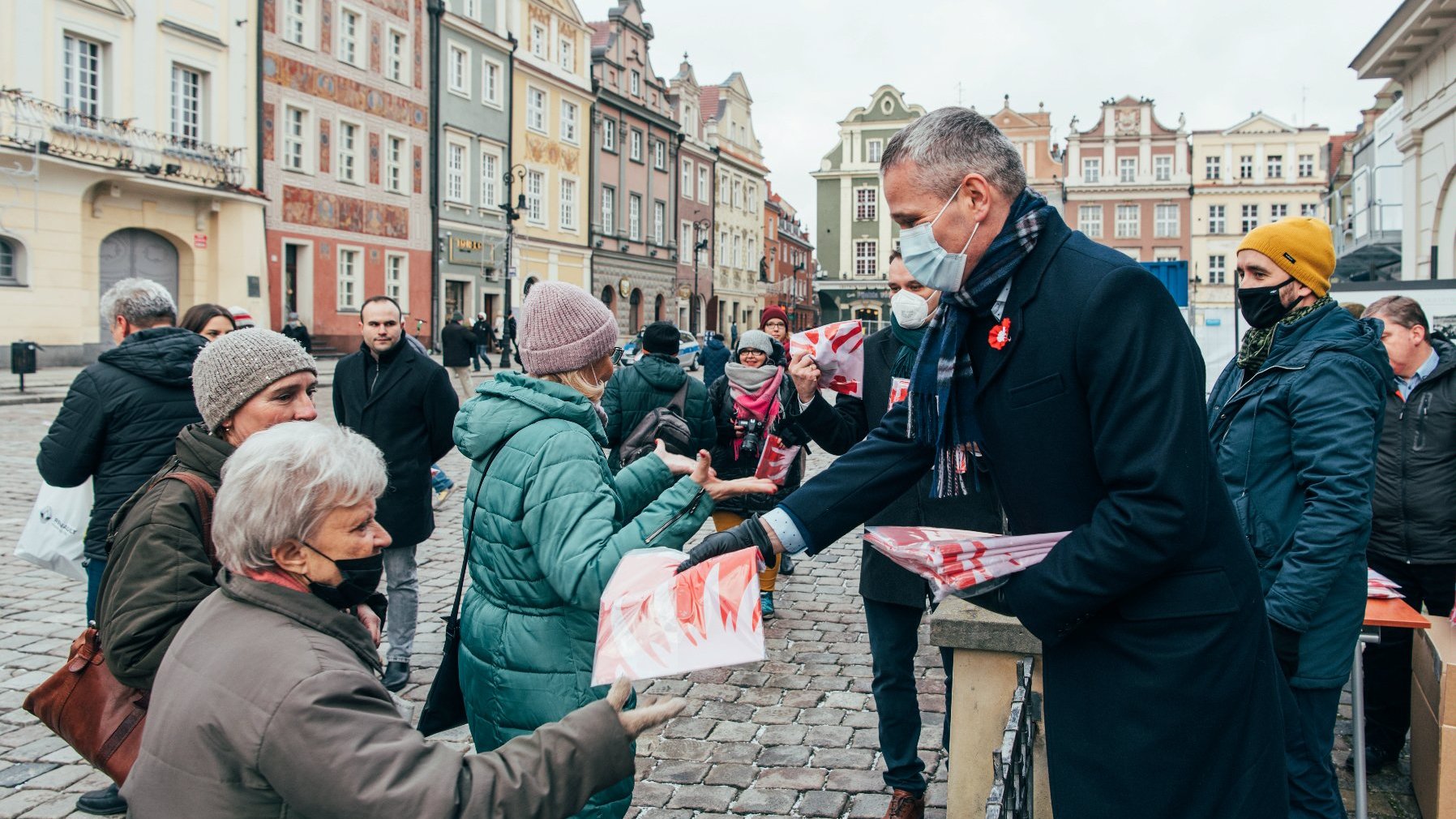 Galeria zdjęć przedstawia akcję rozdawania flag powstańczych poznaniakom na Starym Rynku.