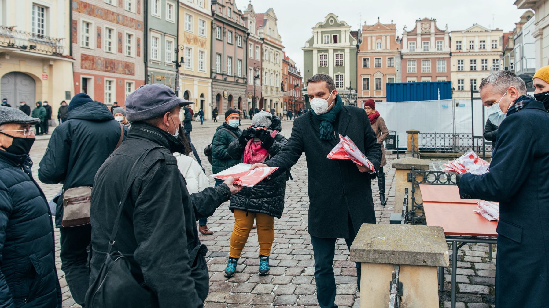 Galeria zdjęć przedstawia akcję rozdawania flag powstańczych poznaniakom na Starym Rynku.