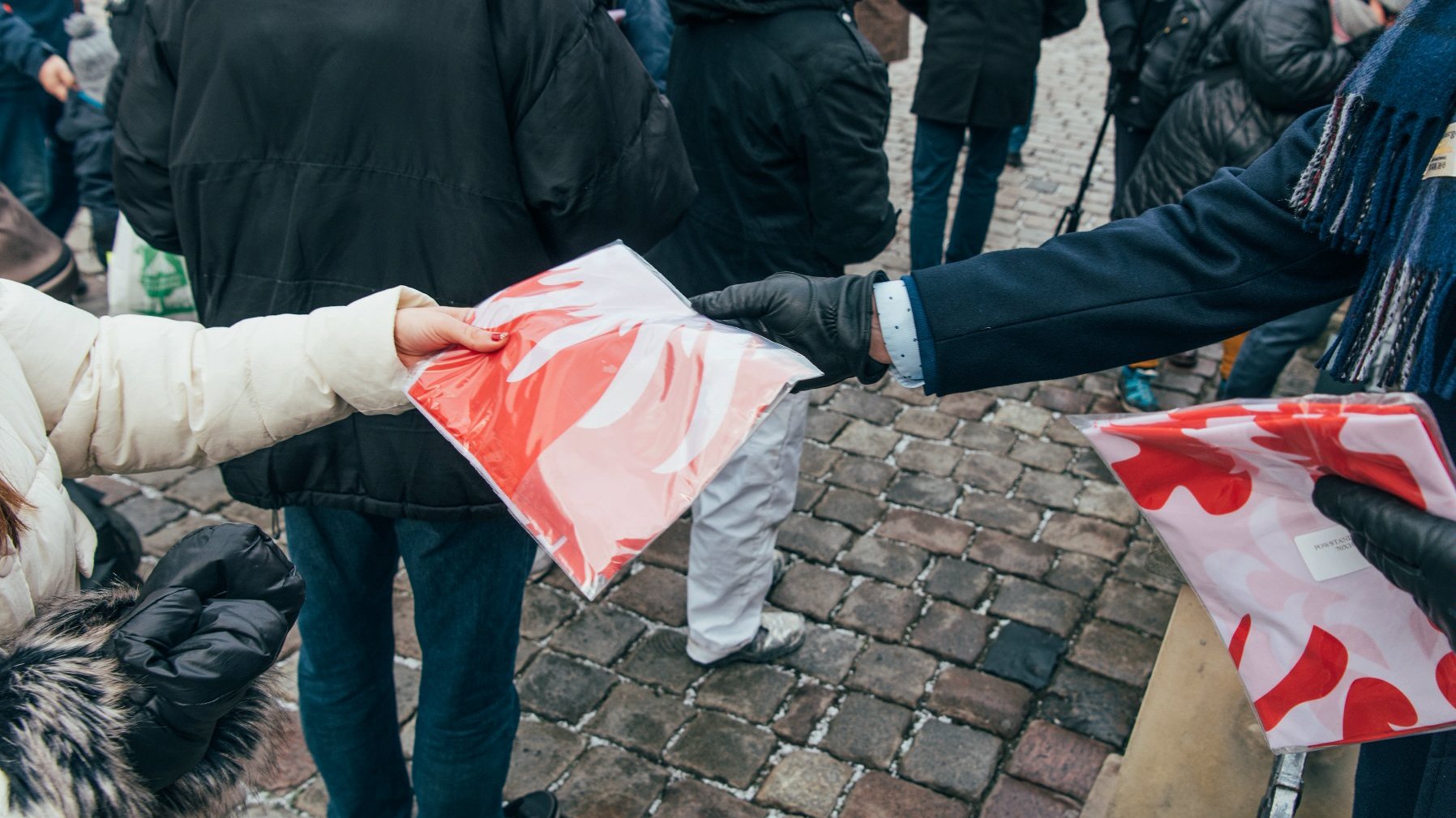 Galeria zdjęć przedstawia akcję rozdawania flag powstańczych poznaniakom na Starym Rynku.