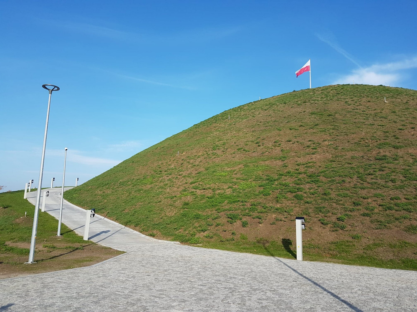 Kopiec Wolności z biało-czerwoną flagą na szczycie - grafika rozmowy