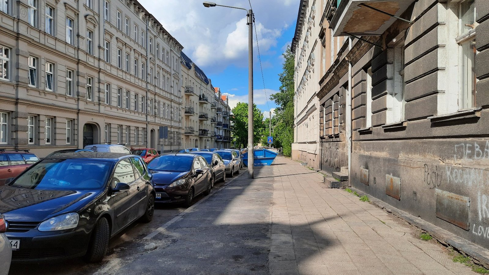 Na zdjęciu ulica z chodnikiem wymagającym remontu, bez roślin