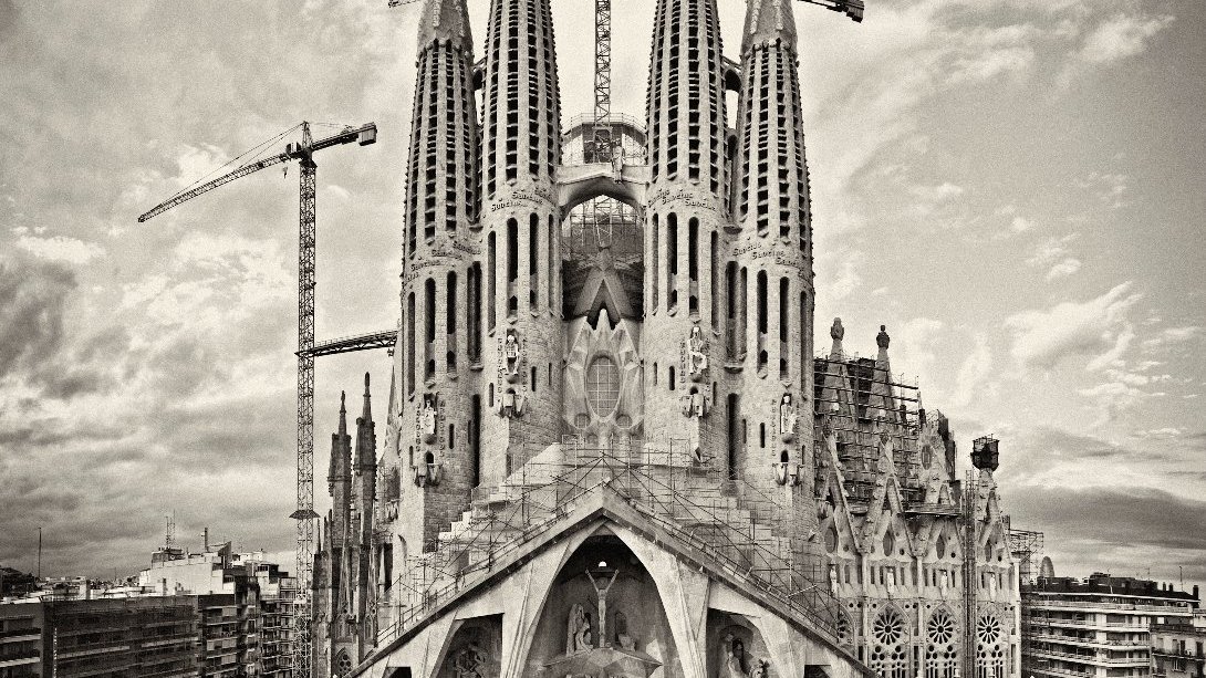 Fasada świątyni Sagrada Família. Nad strzelistymi wieżami budowli widać dzwigi.