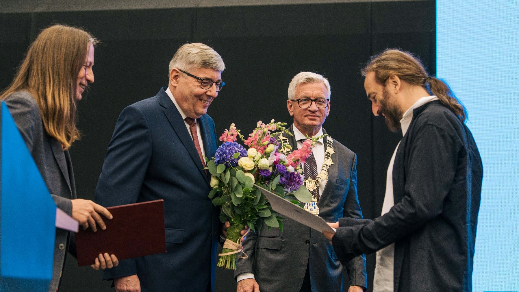 Na zdjęciu Maciej Rychły odbiera Nagrodę Artystyczną Miasta Poznania - grafika rozmowy