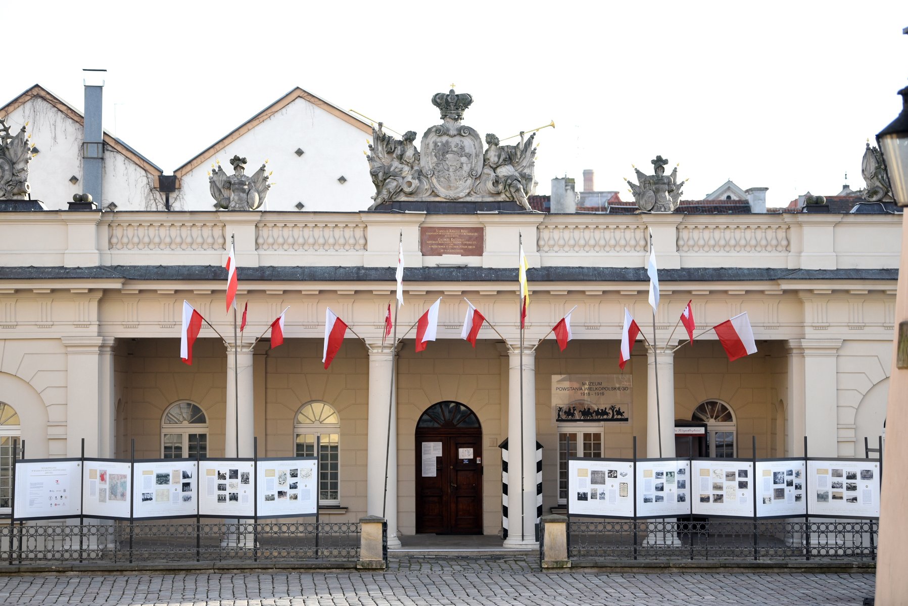 Przystrojona biało-czerwonymi flagami fasada budynku Muzeum Powstania Wielkopolskiego. - grafika rozmowy