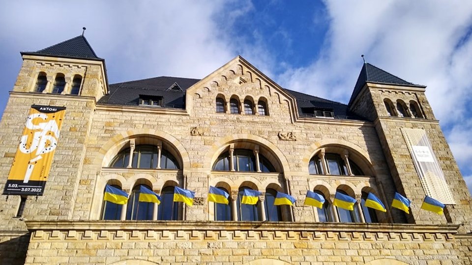 Zdjęcie przedstawia ukraińskie, niebiesko-żółte flagi powiewające na Centrum Kultury Zamek.