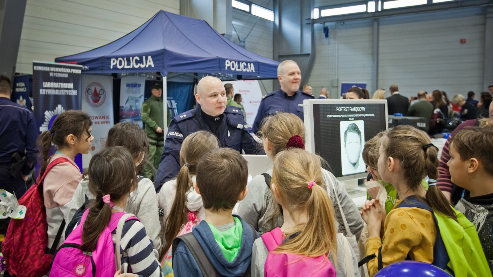 Galeria zdjęć przedstawia tłum ludzi na targowych stoiskach.