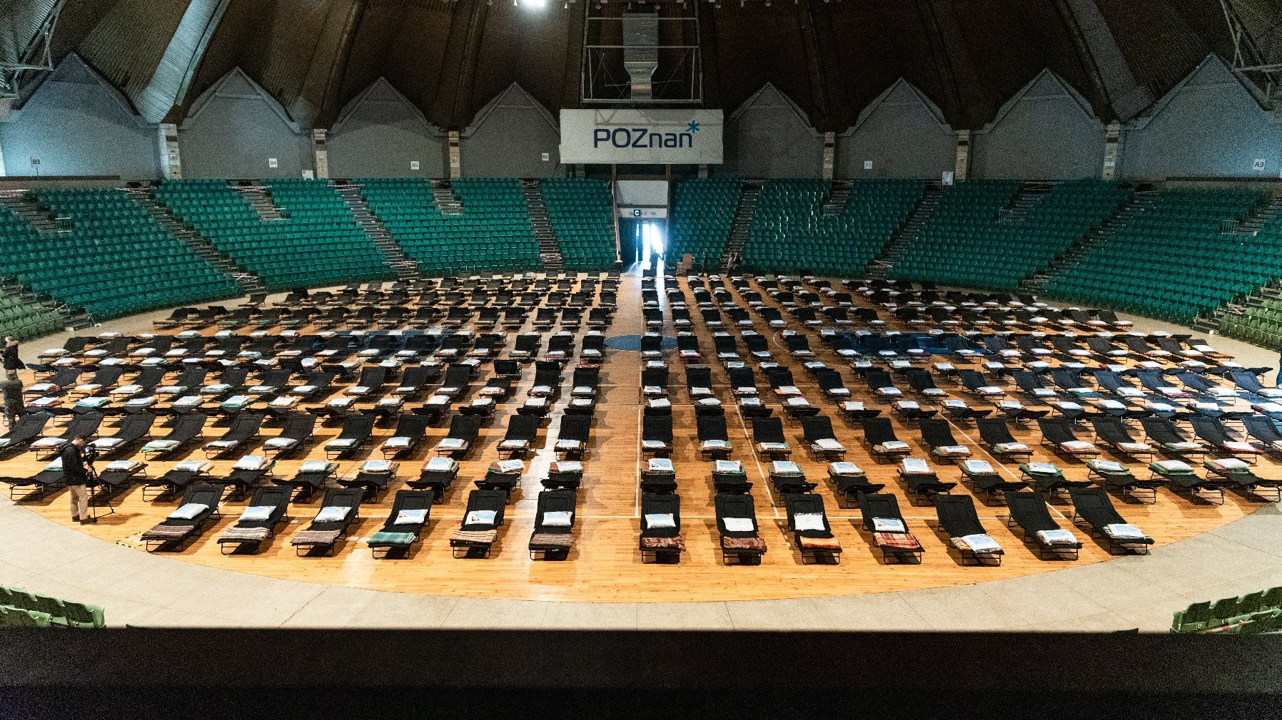 Wnętrze hali Arena. Na środki obiektu widać setki łóżek polowych.